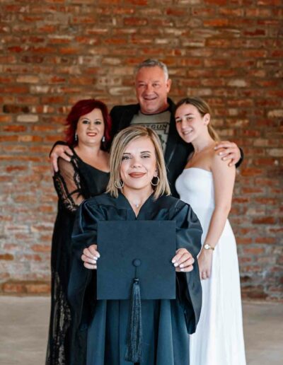 Graduation photography: A young graduate in a cap and gown, standing confidently with a diploma in hand, amidst the backdrop of their alma mater or a picturesque campus scene, symbolizing achievement and the beginning of a new chapter.