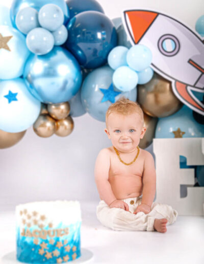Cake smash photography: An adorable baby gleefully smashing a colorful birthday cake with their hands, surrounded by festive decorations and laughter, capturing the joy and excitement of their first birthday celebration.