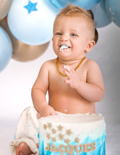 Cake smash photography: An adorable baby gleefully smashing a colorful birthday cake with their hands, surrounded by festive decorations and laughter, capturing the joy and excitement of their first birthday celebration.