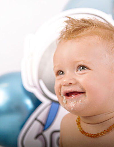 Cake smash photography: An adorable baby gleefully smashing a colorful birthday cake with their hands, surrounded by festive decorations and laughter, capturing the joy and excitement of their first birthday celebration.